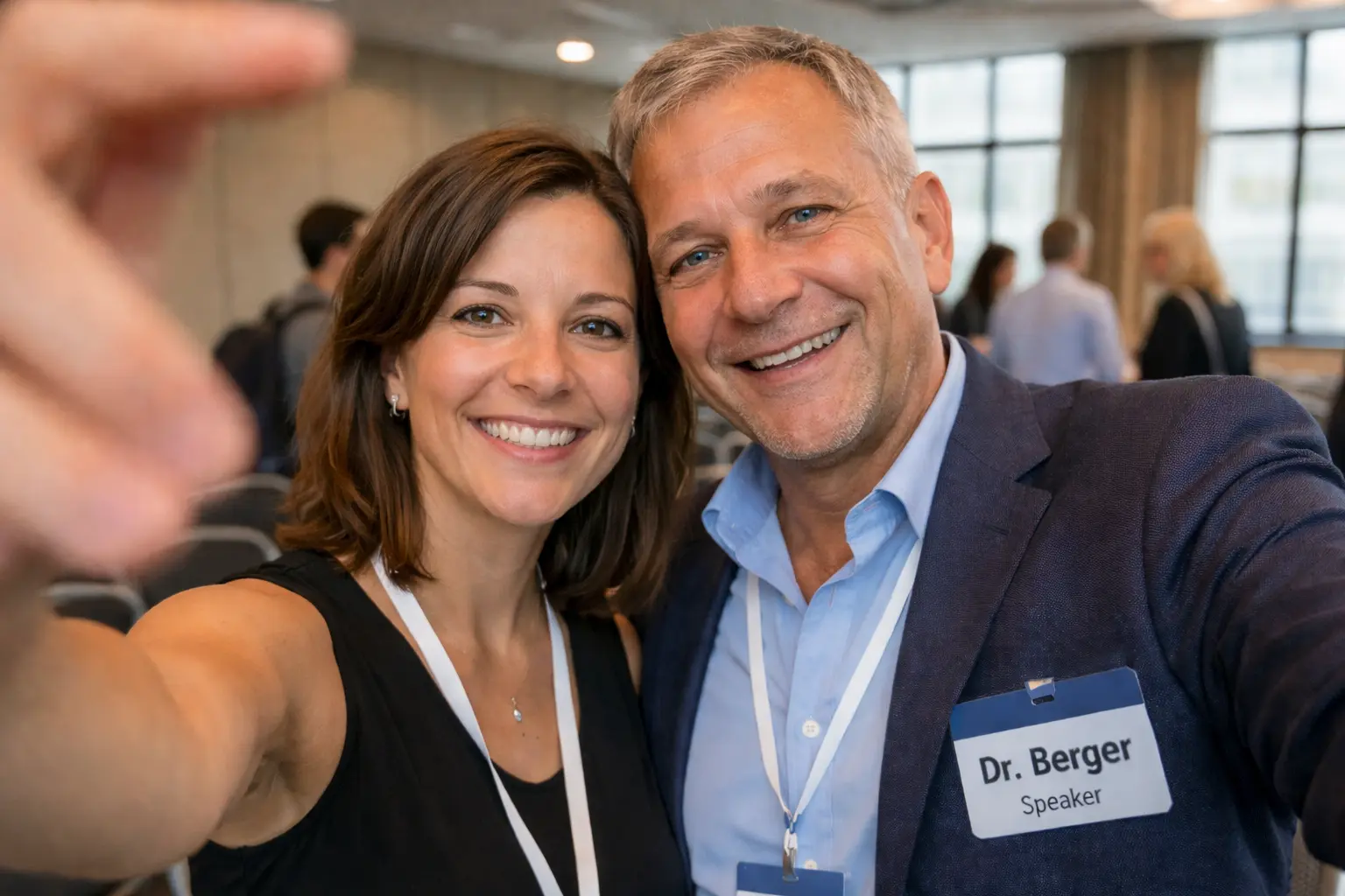 Д-р Бергер и Деси Петрова разговарят в конферентна зала след лекция — двамата с баджове, естествен кадър